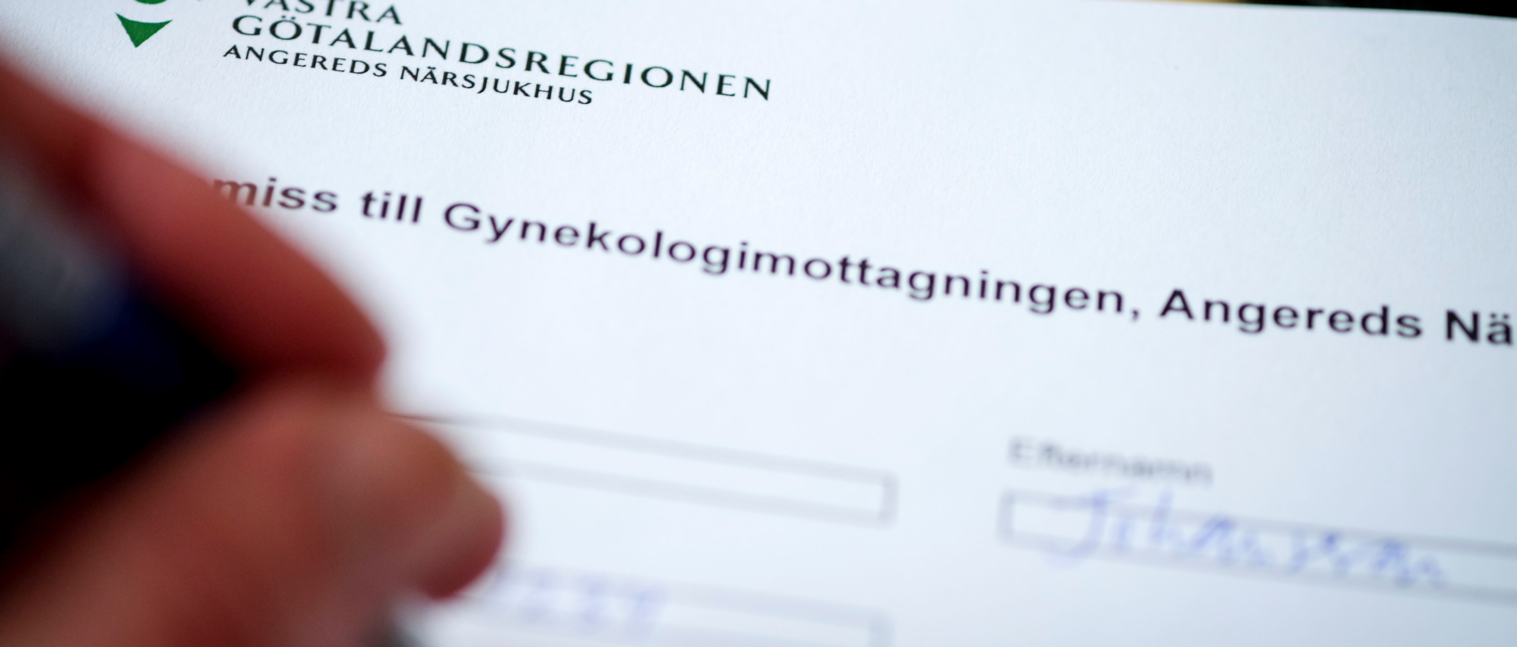 Hand med penna som fyller i blankett.