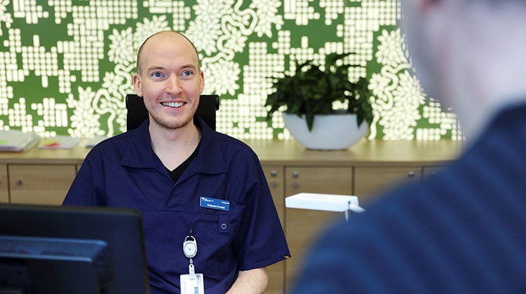 Sjukhusvärd tar emot i receptionen.