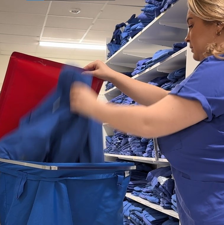 Medarbetare lägger tvätt i en tvättsäck