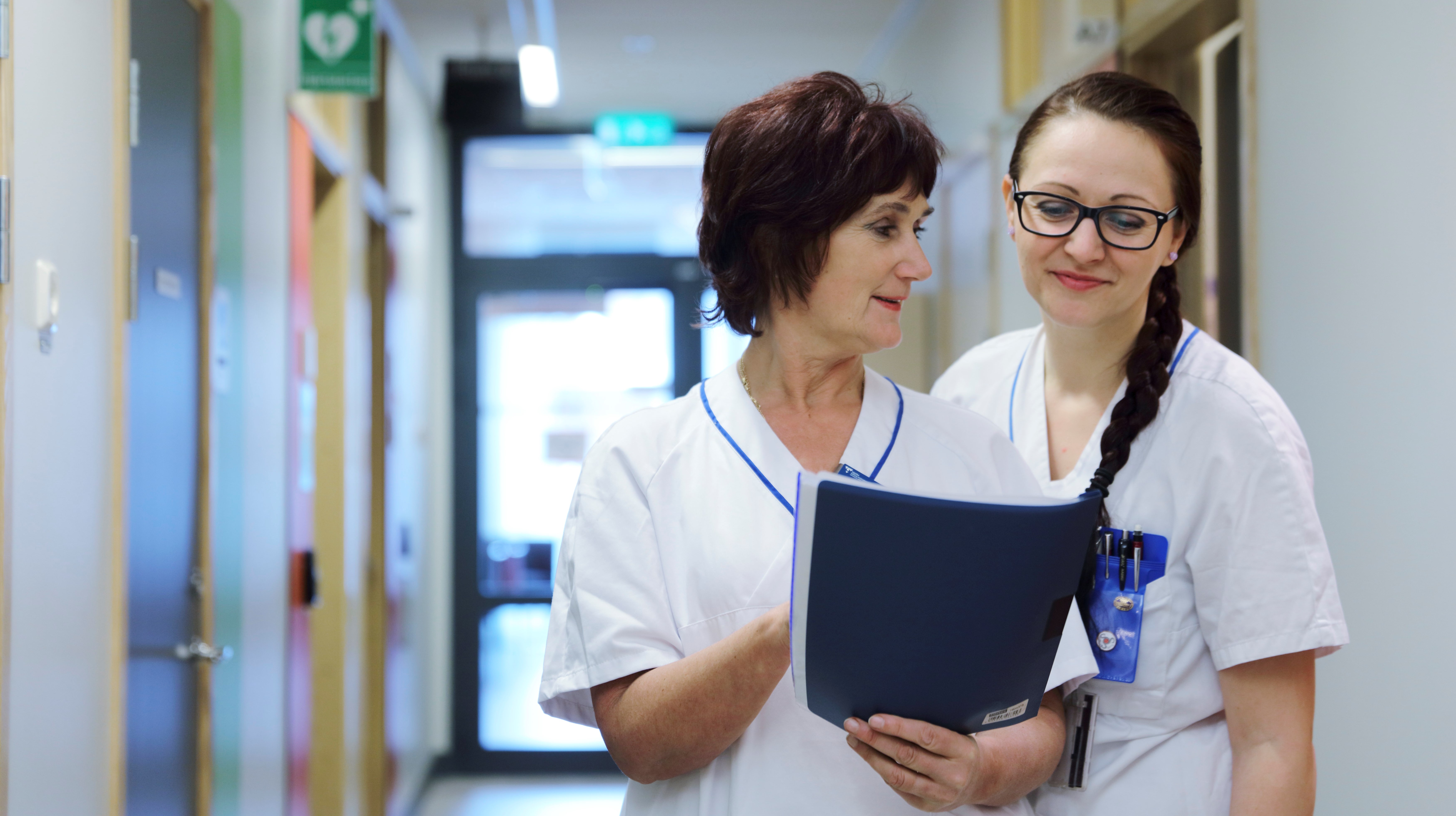 Vårdpersonal diskuterar, med journal i handen